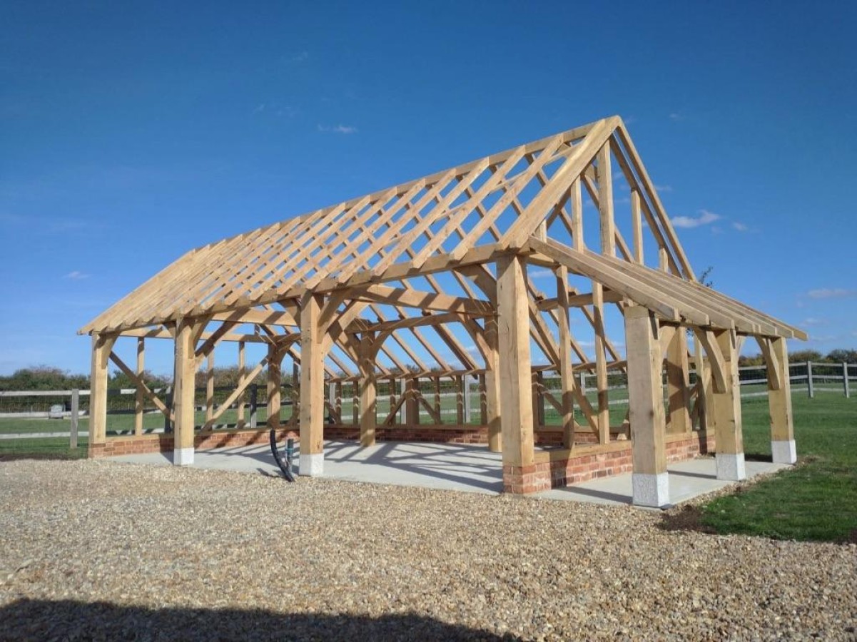 oak framed garage on brick foundation with hipped roof and catslide in garden